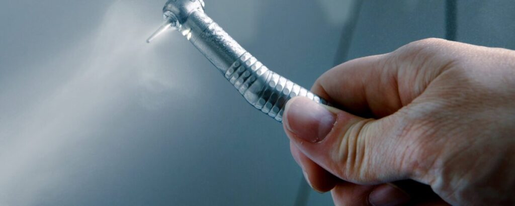 A Dentist holding dental tool