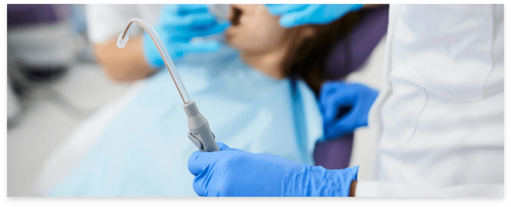 Close-up of dentist using dental suction